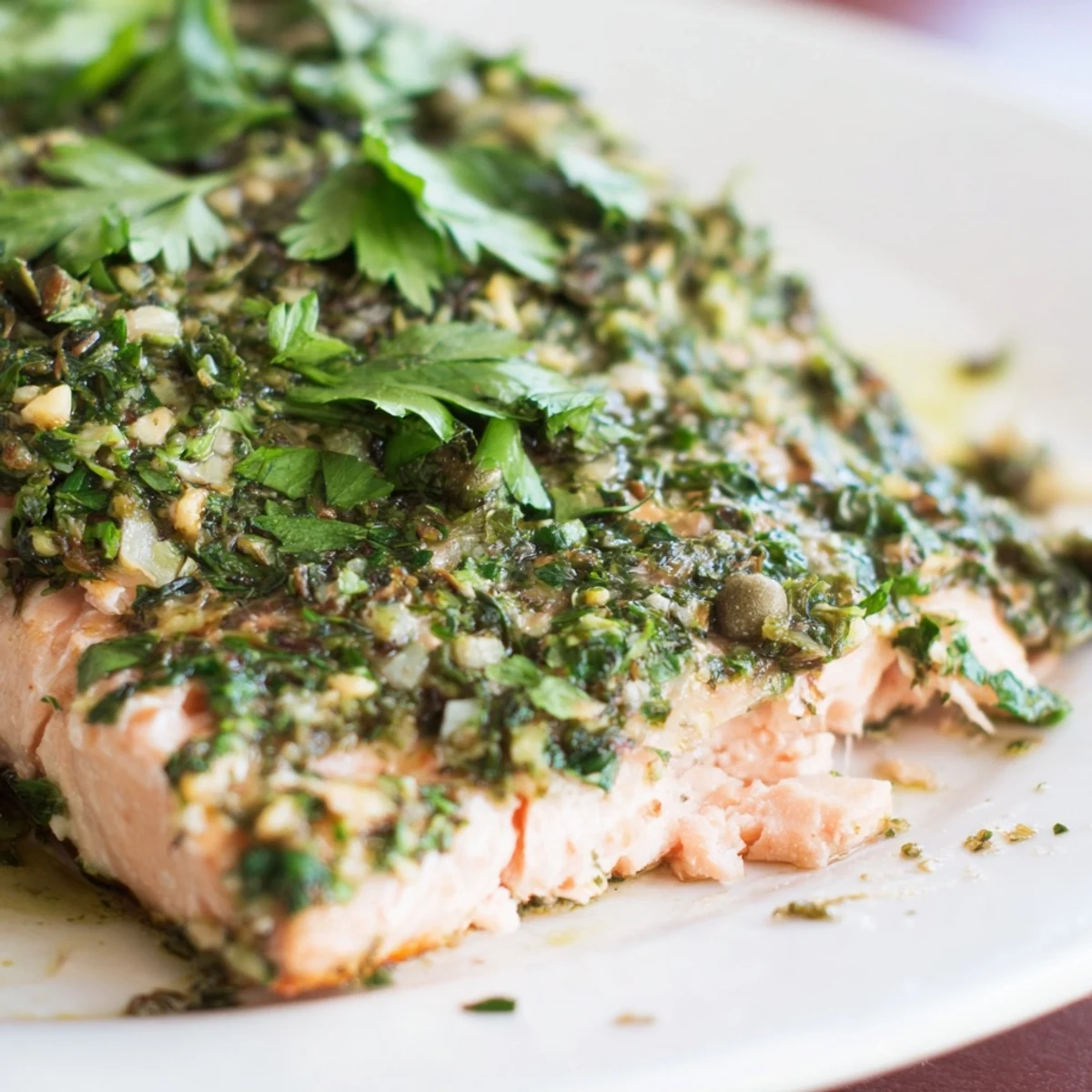 Perfectly cooked Baked Salmon with Salsa Verde flaking easily with a fork, drizzled with extra virgin olive oil and a squeeze of fresh lemon.