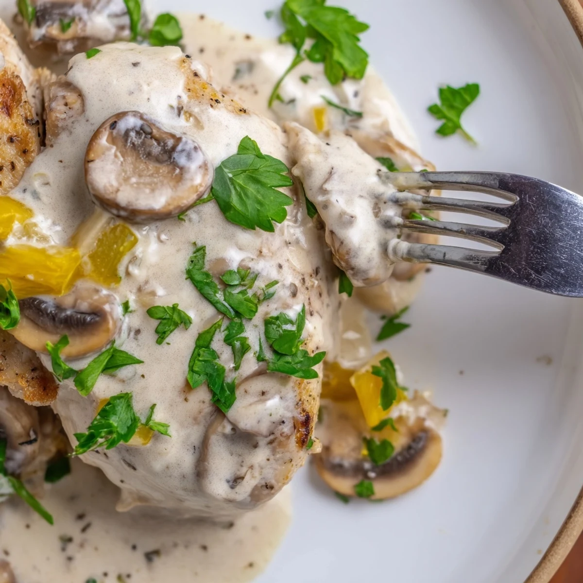 Savory Creamy Garlic Mushroom Chicken Breasts served with mashed potatoes and fresh parsley garnish.