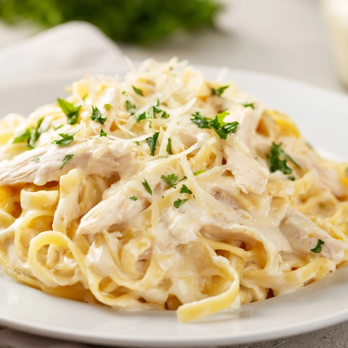 Creamy Alfredo Pasta with Chicken served in a white bowl, garnished with parsley and extra Parmesan for a cozy dinner.