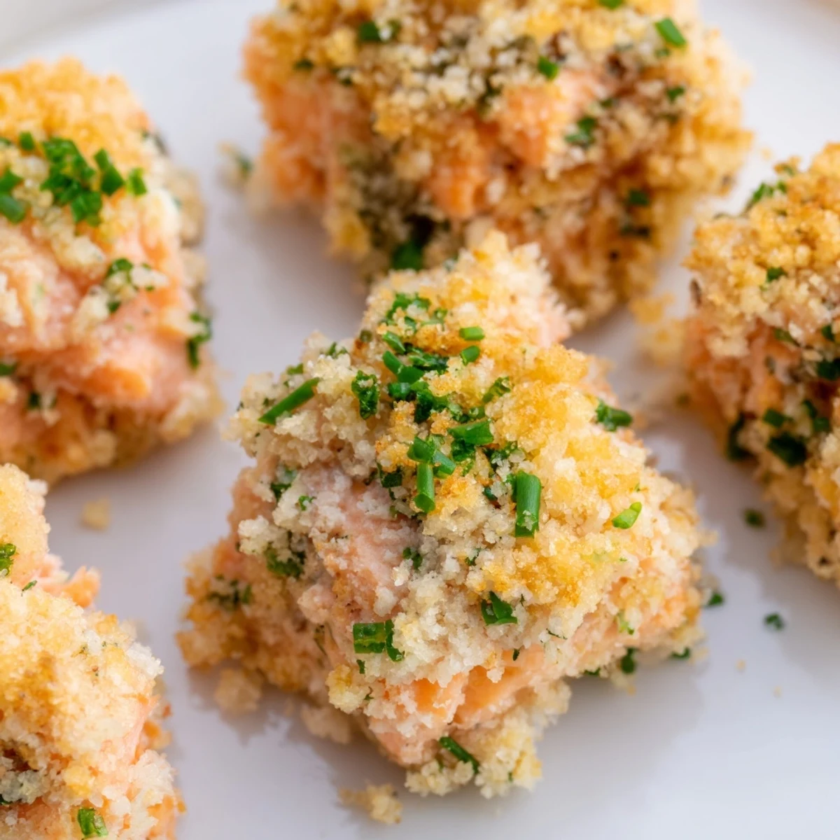 Golden brown Baked Salmon Snack Bites fresh from the oven, garnished with fresh dill and lemon wedges.