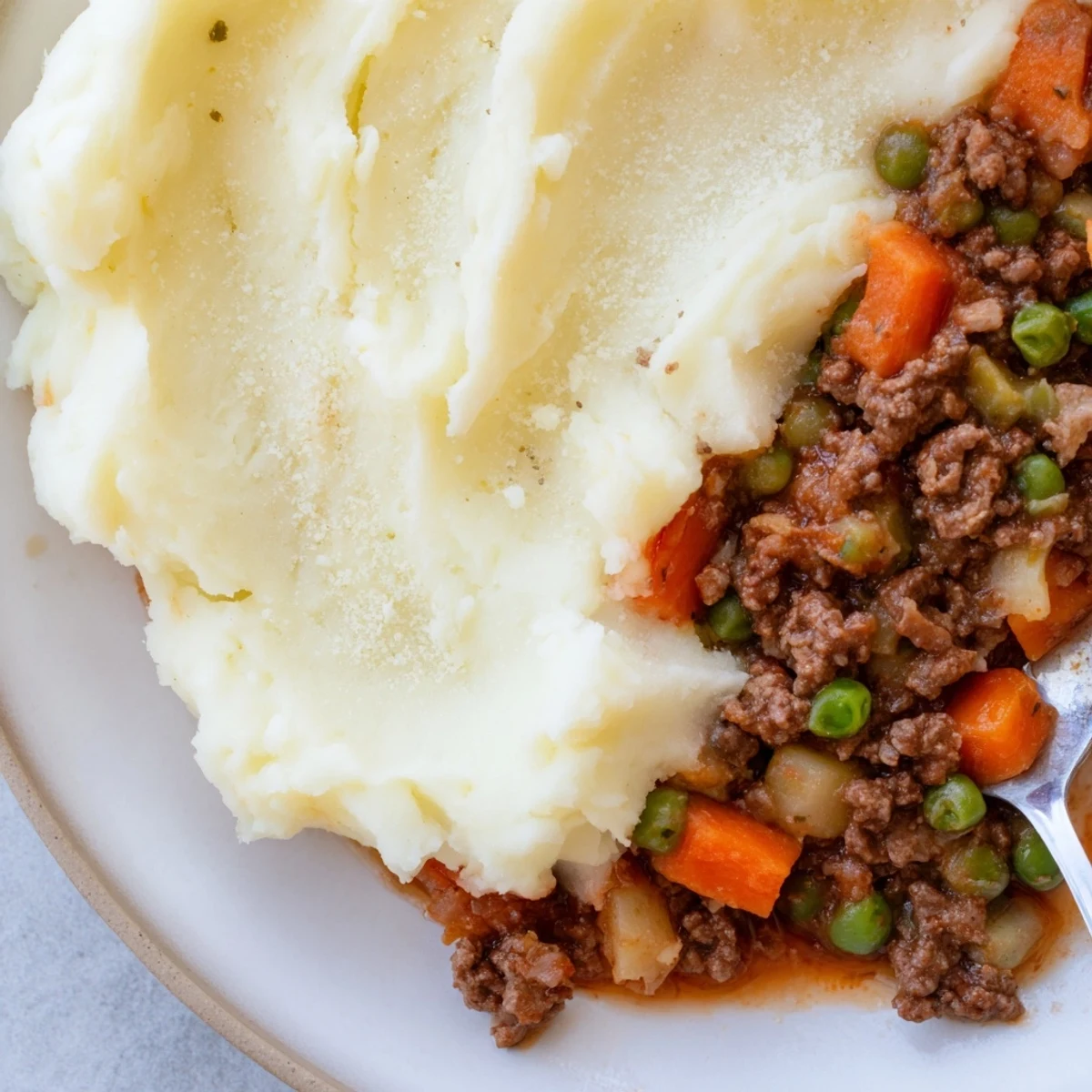 Golden brown Beef Shepherds Pie with Cauliflower Mash bubbling in a ceramic dish ready to serve.