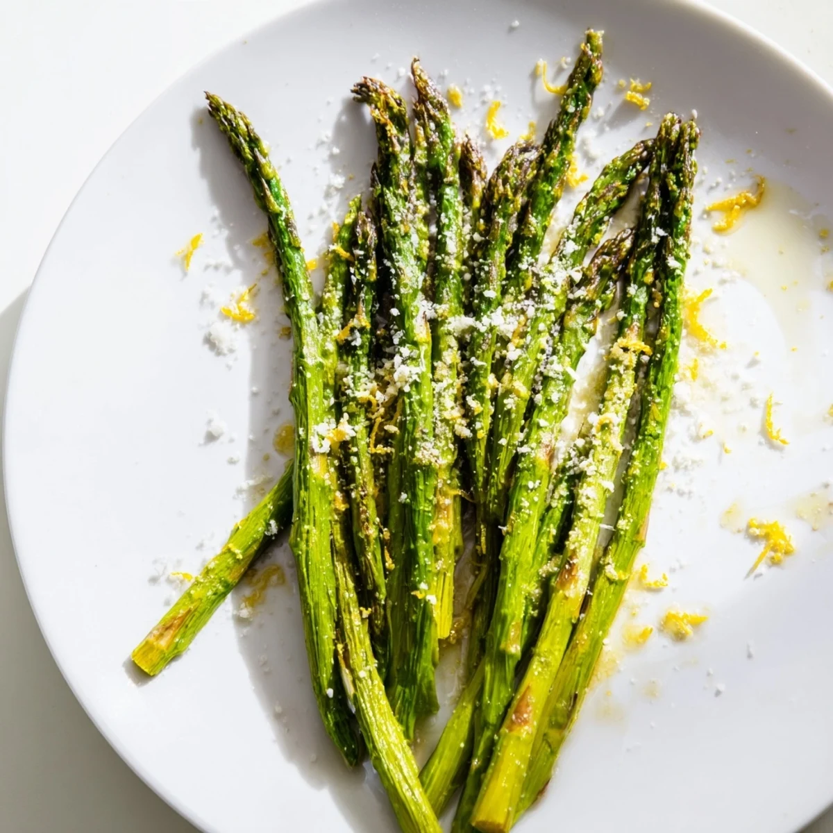 Tender roasted asparagus spears with melted Parmesan and fresh lemon zest, served warm on a baking sheet.