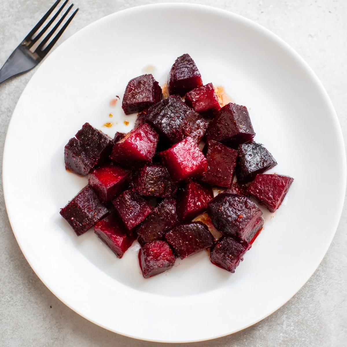 Golden, tender roasted beets tossed in balsamic glaze for a vegan easy roasted beets recipe on a baking sheet.