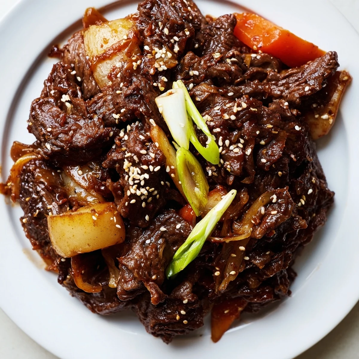 Korean Style Pot Roast shredded and served over steamed rice with a spoonful of vegetables.