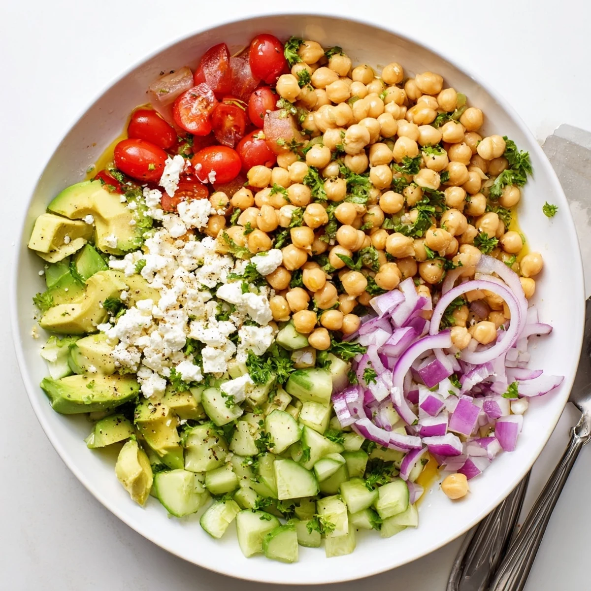 Bright lemon dressing coats hearty chickpeas and crisp vegetables in this colorful Chickpea Feta Avocado Salad.