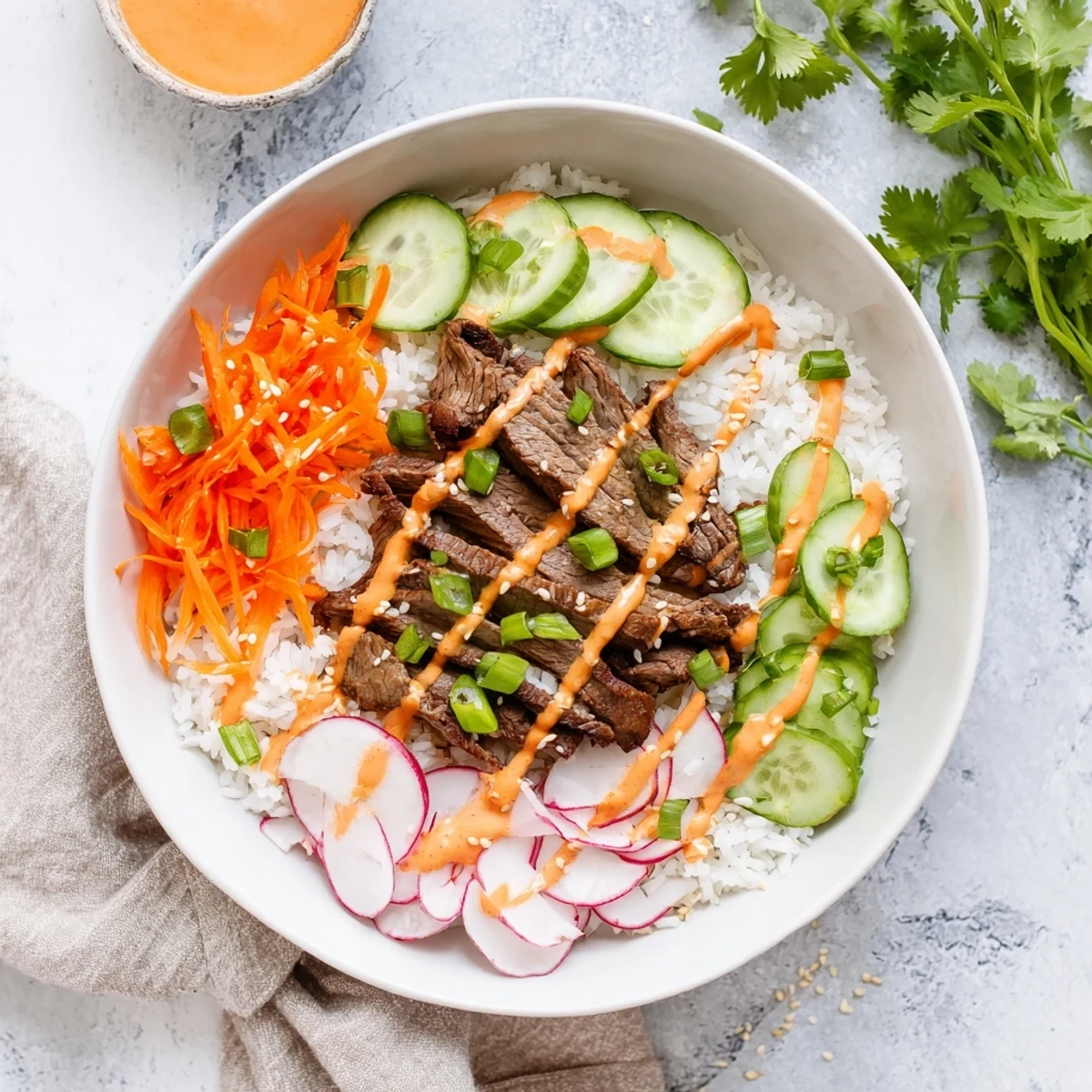 A close-up of Irresistibly Easy Korean BBQ Steak Rice Bowls with Spicy Cream Sauce, featuring tender glazed steak and creamy drizzle over rice and crisp veggies.