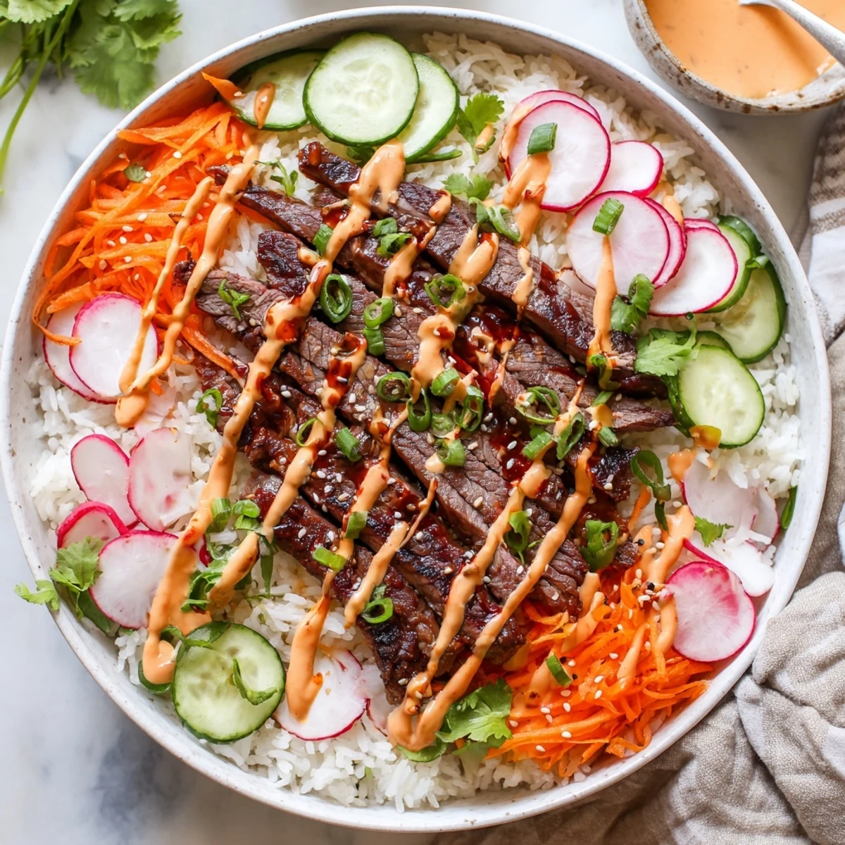 This vibrant Irresistibly Easy Korean BBQ Steak Rice Bowls with Spicy Cream Sauce photo shows fluffy rice topped with marinated beef, crunchy carrots, cucumber, and spicy sauce.