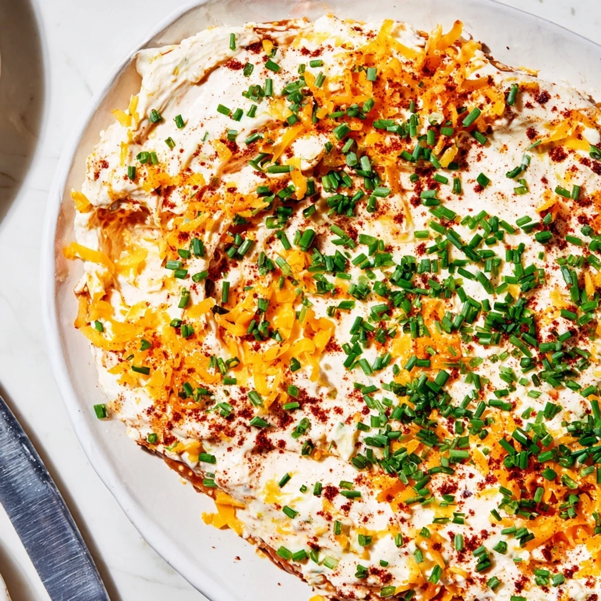 Golden sharp cheddar savory pretzel dip with Dijon mustard garnished with fresh chives