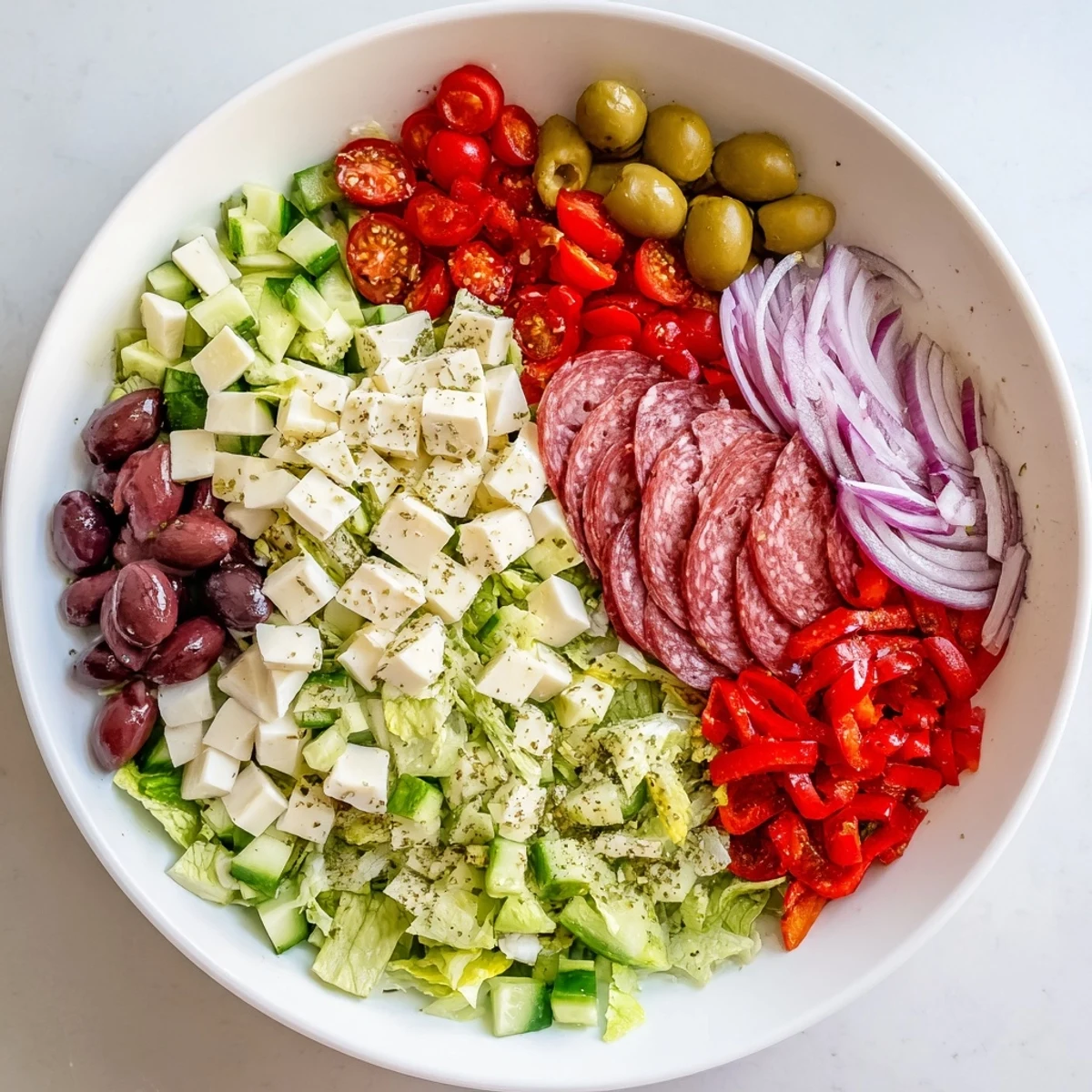 Vibrant chopped salad with Romaine, roasted red peppers, salami cubes and homemade Italian dressing ready to serve