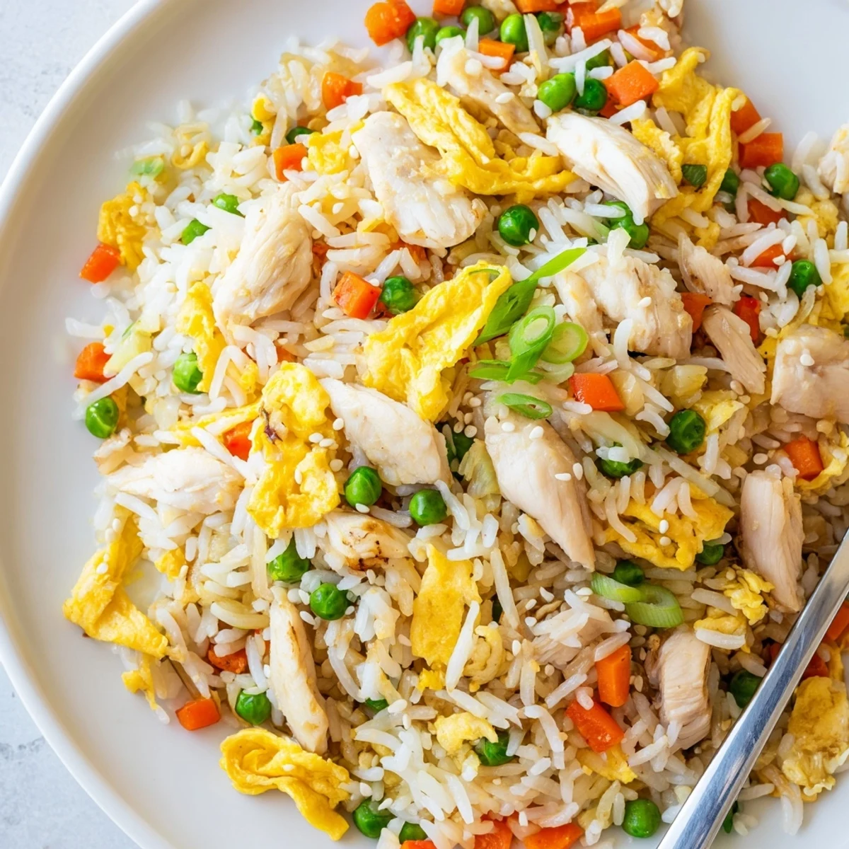Flavorful stir-fried rice with tender chicken pieces garnished with golden egg omelette strips