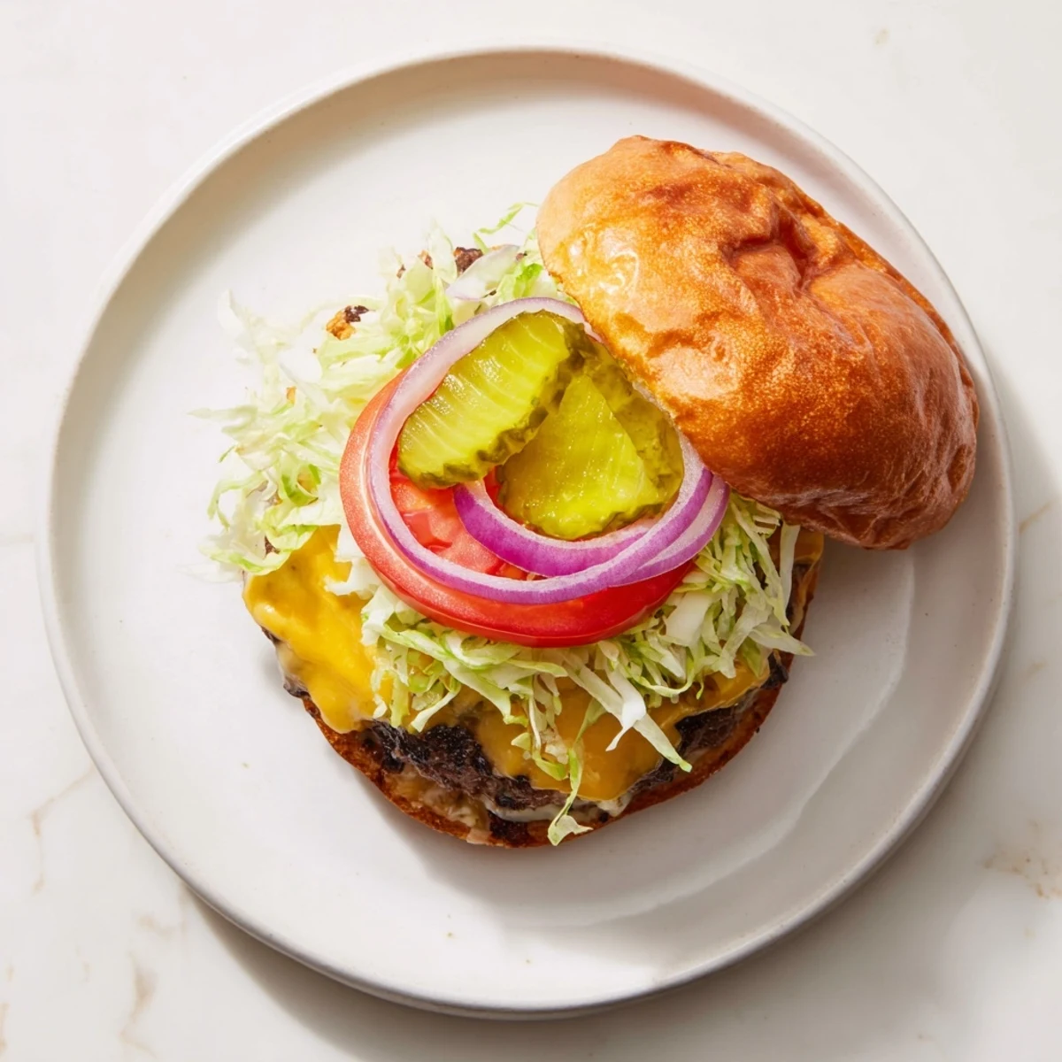 Juicy beef smash burger patty with American cheese melted over the crispy edges served on a buttered bun