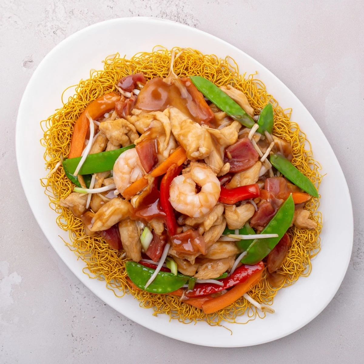Cantonese chow mein served family-style with caramelized noodle base crowned with protein-rich vegetable stir-fry and rich glaze