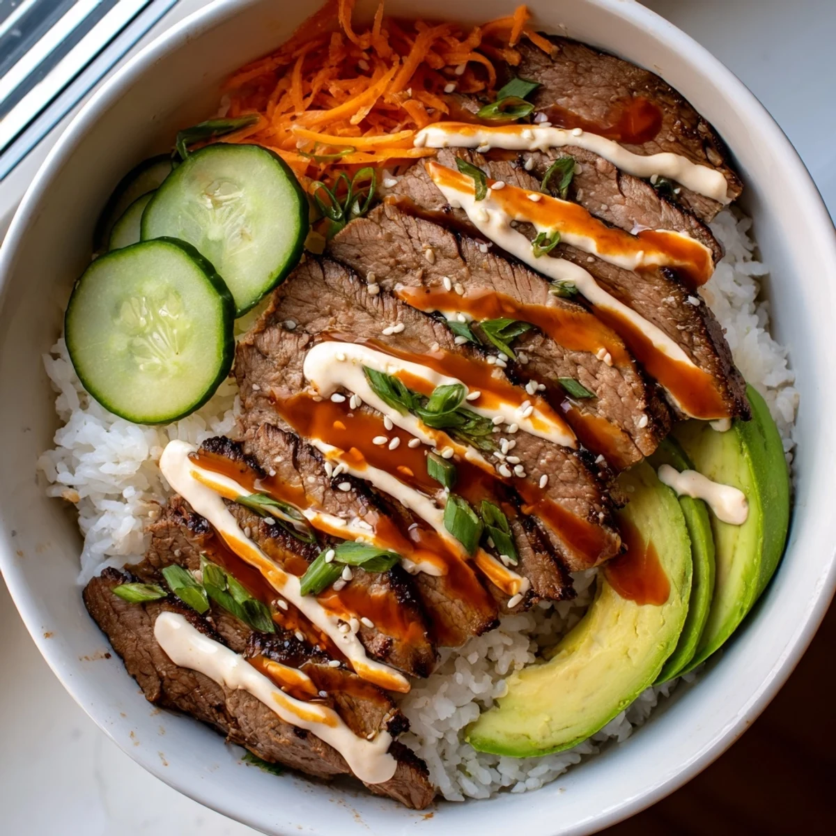 Protein-packed flank steak bowl with juicy steak slices, edamame, cucumber, and creamy lime sauce