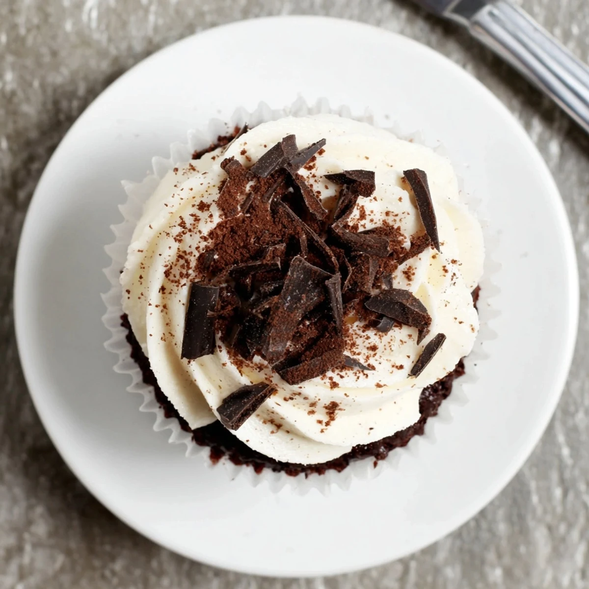 Rich chocolate cupcakes filled with coffee syrup and creamy mascarpone frosting on white plate