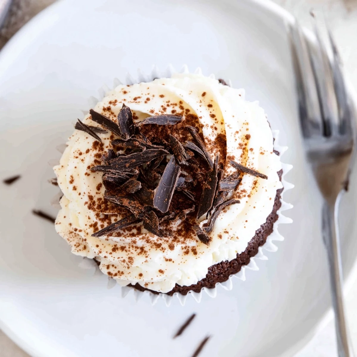 Chocolate tiramisu cupcakes garnished with dark chocolate shavings and coffee-soaked sponge layers