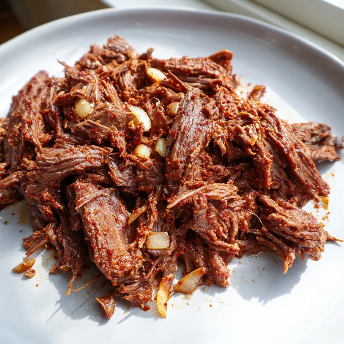 Slow-cooked Crock Pot shredded beef with aromatic spices, ready for serving over rice bowls