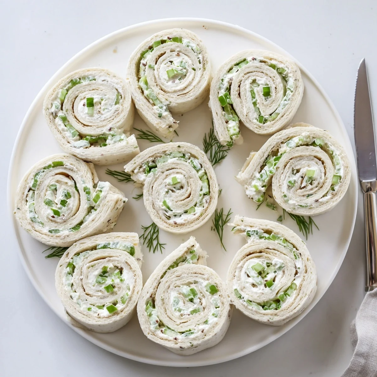 Tangy dill pickle and cream cheese spirals sliced into colorful appetizer pinwheels
