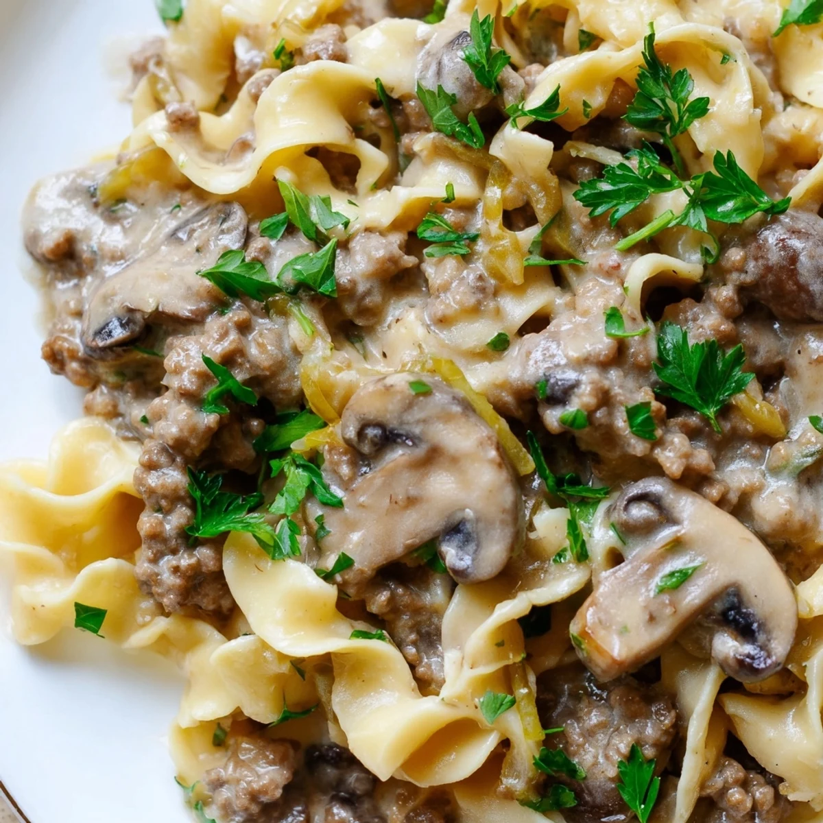 Creamy hamburger stroganoff served over tender egg noodles with fresh parsley garnish
