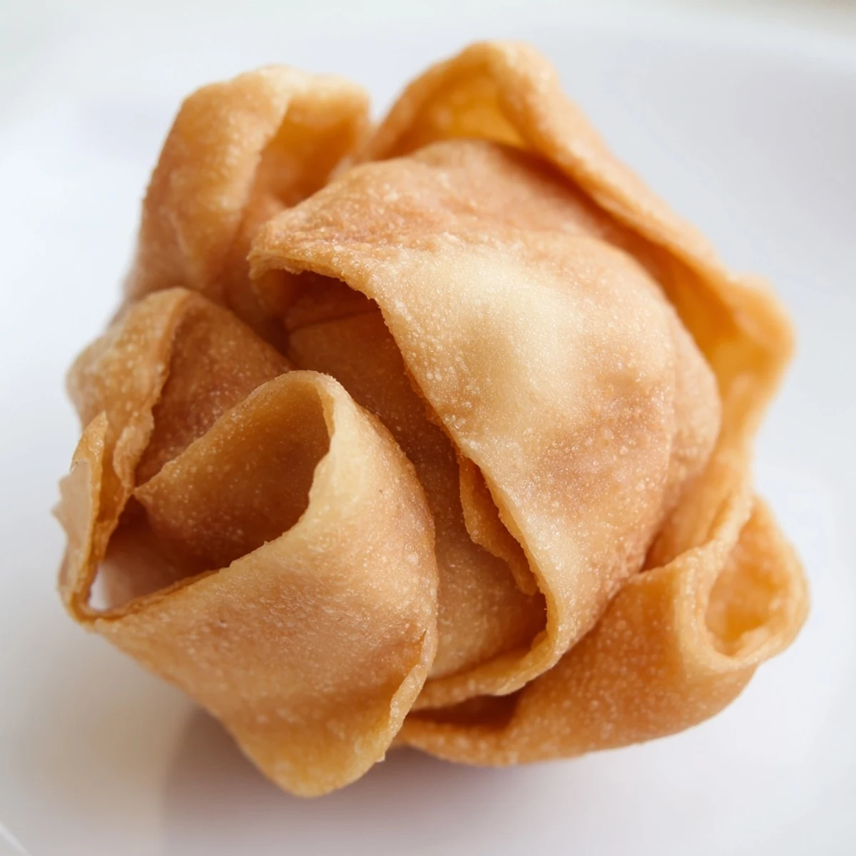 Handheld crispy pastry bites filled with lump crab and cream cheese ready for dipping