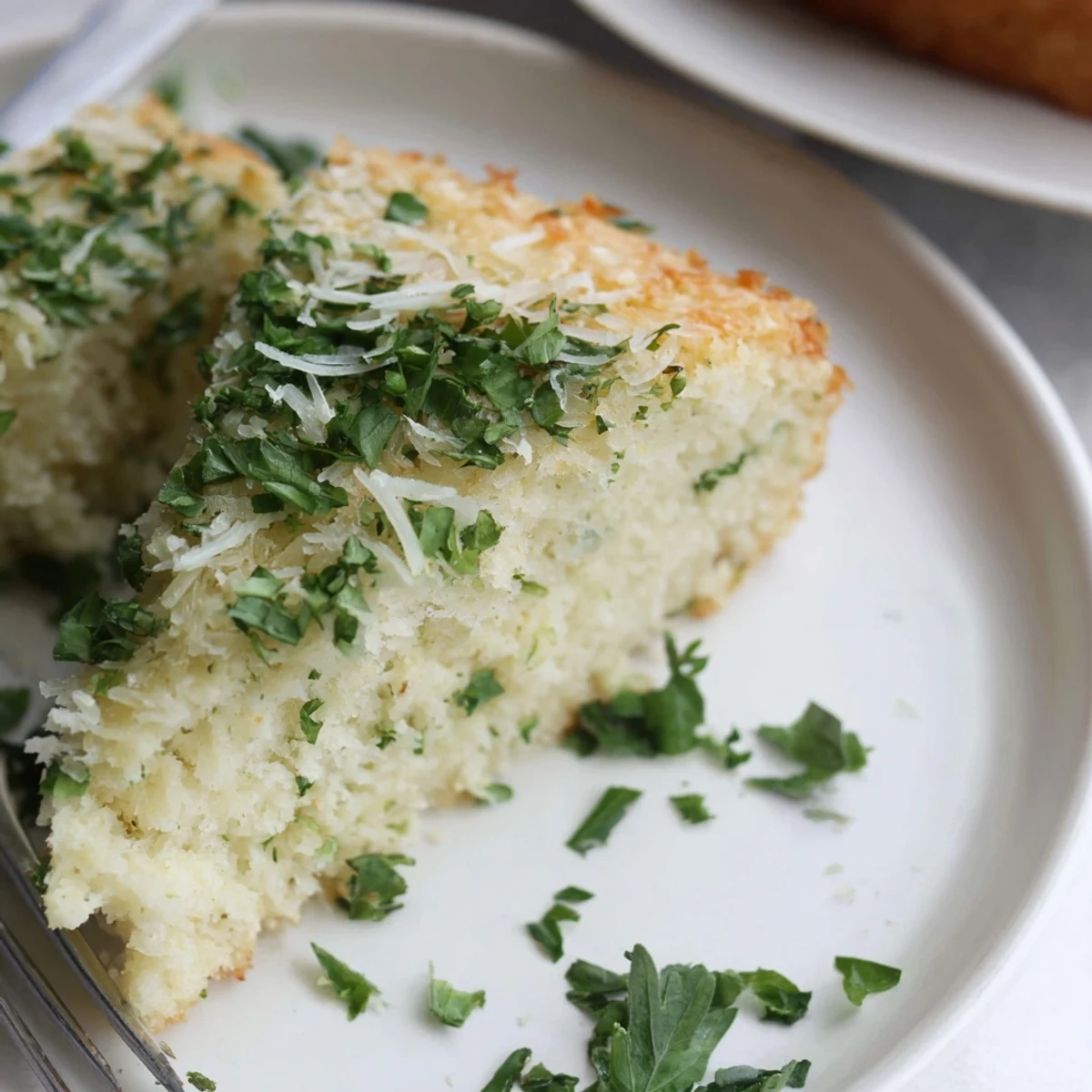 Savory low-carb Parmesan herb keto bread sliced on a wooden cutting board