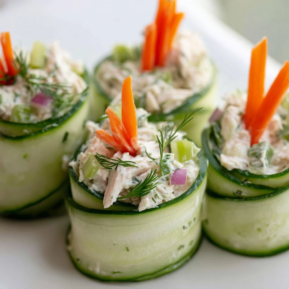 Creamy chicken salad nestled inside cool cucumber ribbons, topped with colorful julienned carrots