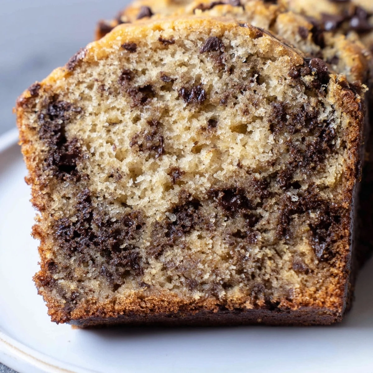 Freshly baked chocolate chip banana bread loaf with golden crust and visible chocolate swirls
