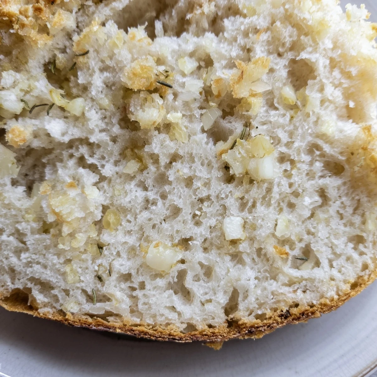 Freshly baked Dutch oven garlic rosemary bread loaf garnished with rosemary sprigs