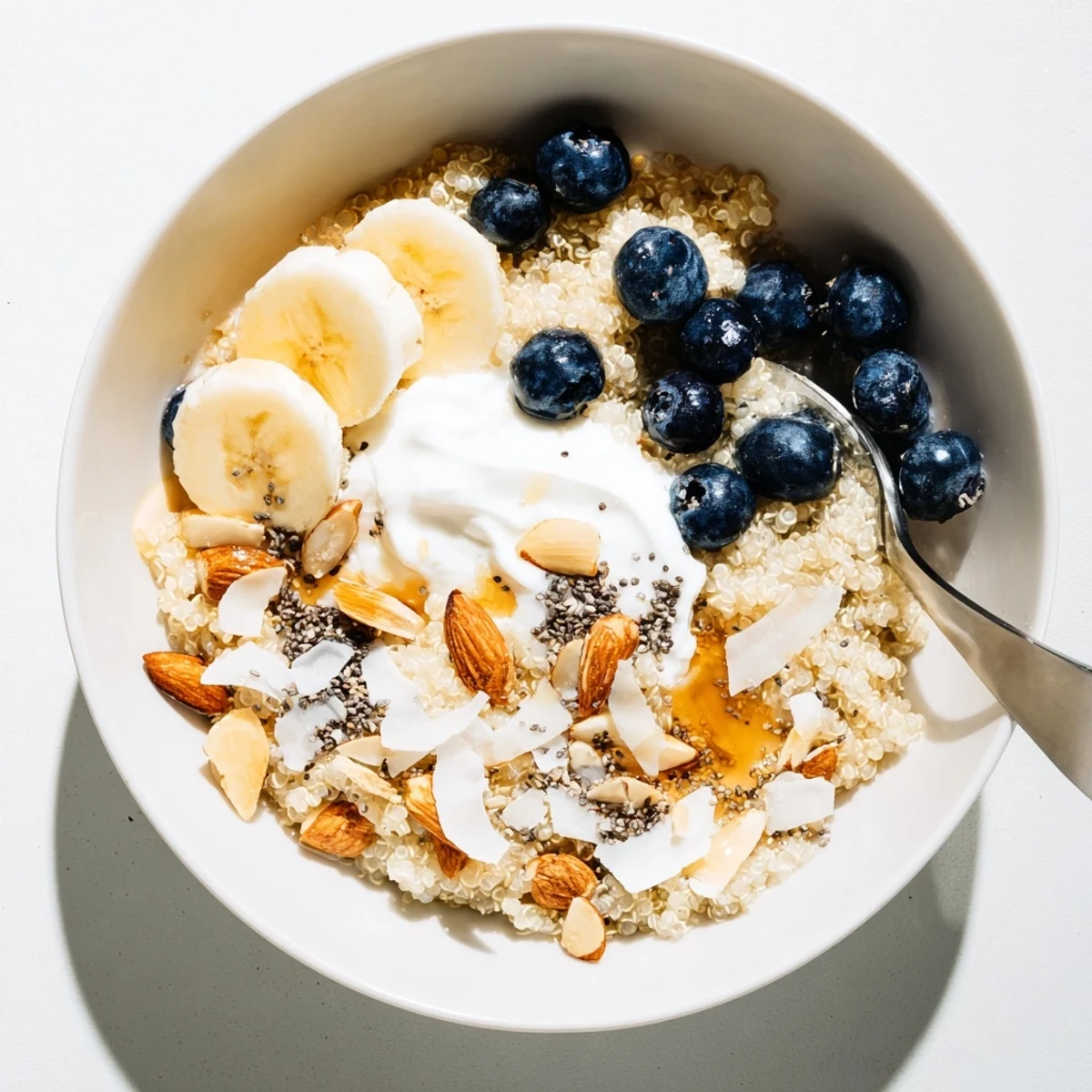 Protein-packed quinoa breakfast bowl with plump blueberries, sliced banana, and Greek yogurt garnish