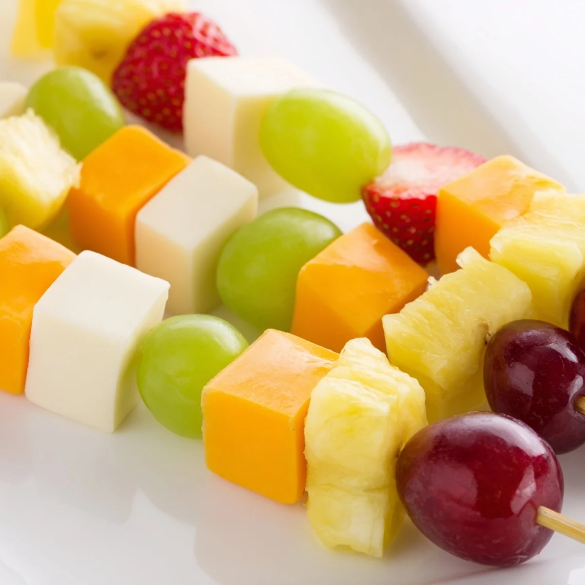 Fresh fruit and cheese kabobs featuring alternating grapes pineapple strawberries and creamy Monterey Jack cubes