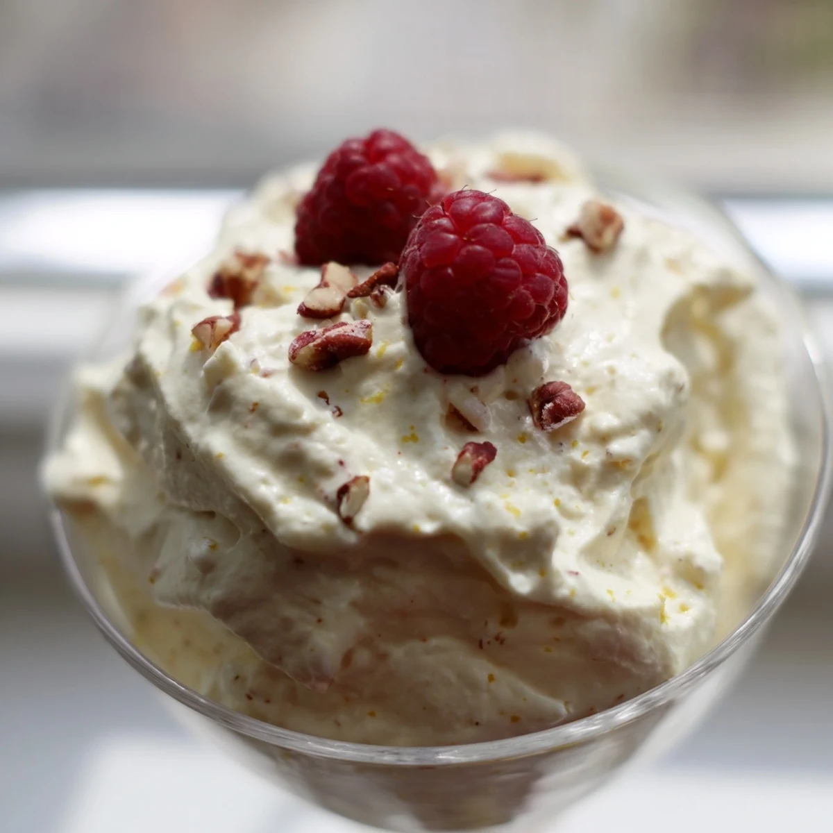 Creamy keto cheesecake fluff scooped into glasses and topped with fresh red berries