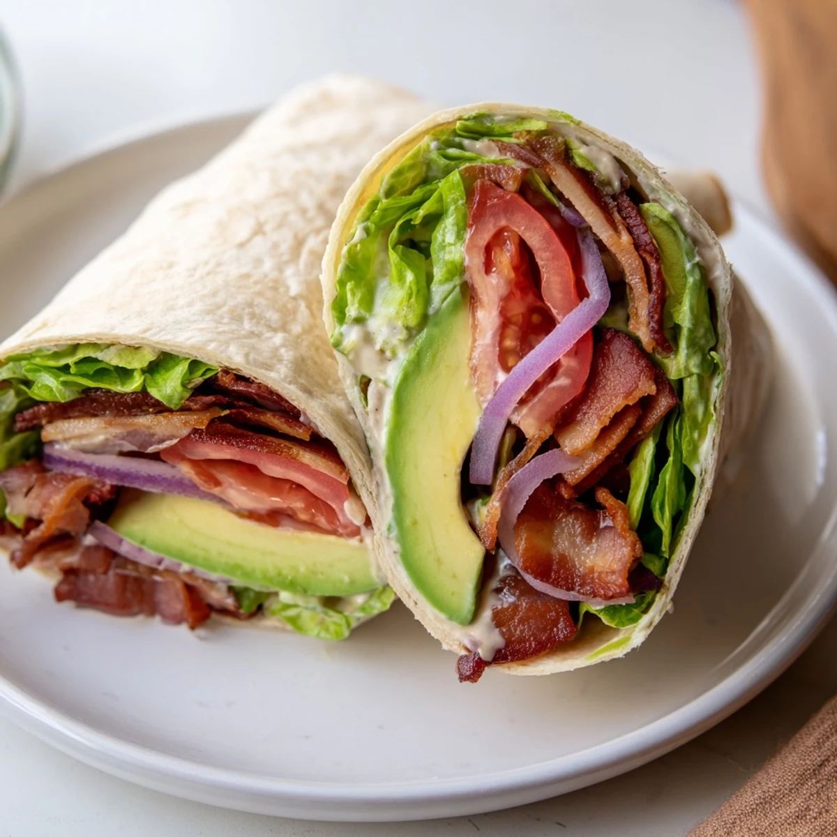 Meal Prep BLT Wraps wrapped in foil for work lunches, dressing glistening