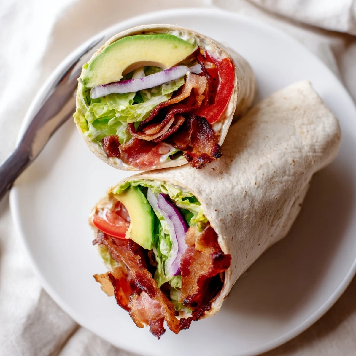 Golden-brown bacon and green romaine peek from Meal Prep BLT Wraps