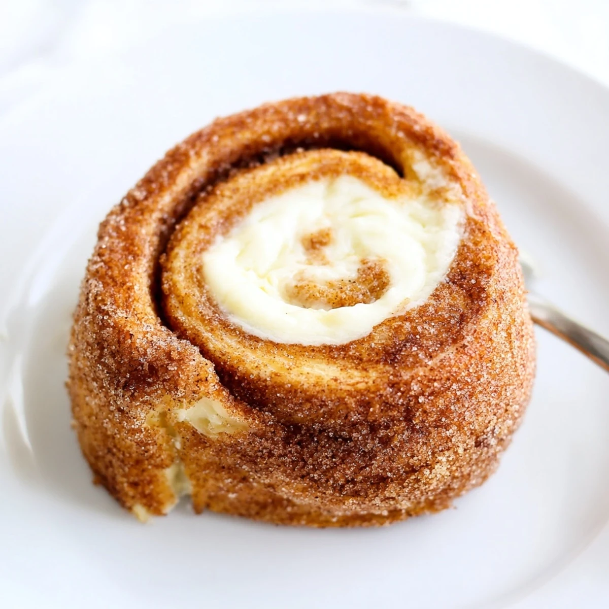 Warm Cinnamon Roll French Toast Roll Ups coated in cinnamon sugar, steaming.