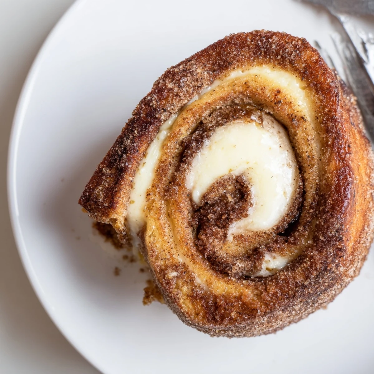 Handheld Cinnamon Roll French Toast Roll Ups drizzled with maple syrup, ready.
