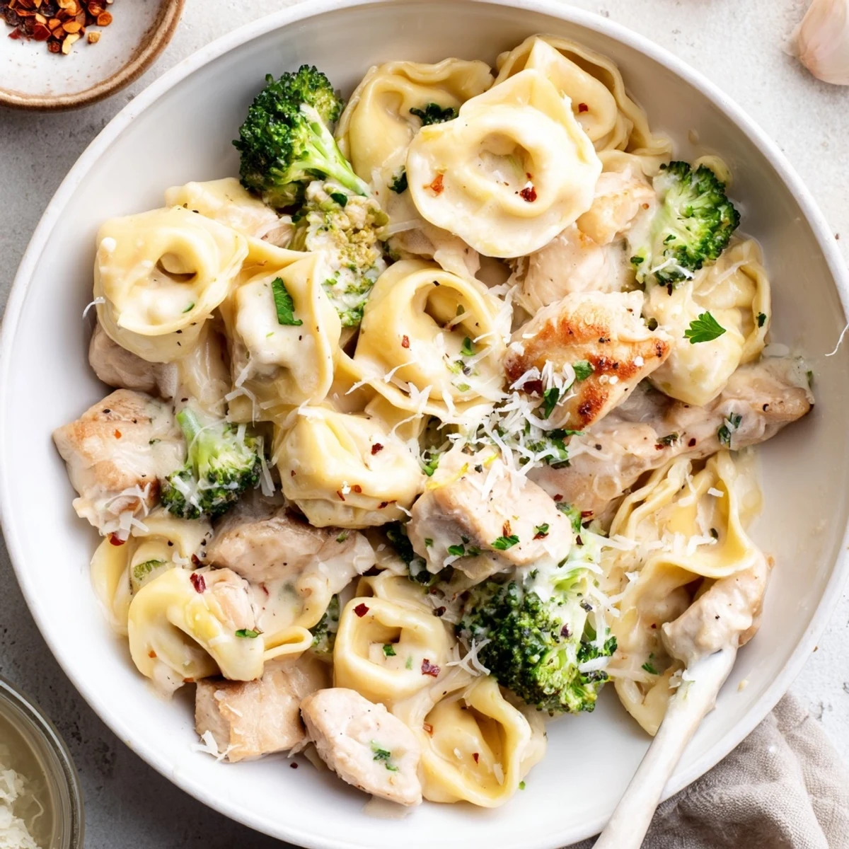 Skillet-ready Creamy Garlic Parmesan Tortellini Chicken Broccoli Recipe with silky sauce, grated Parmesan