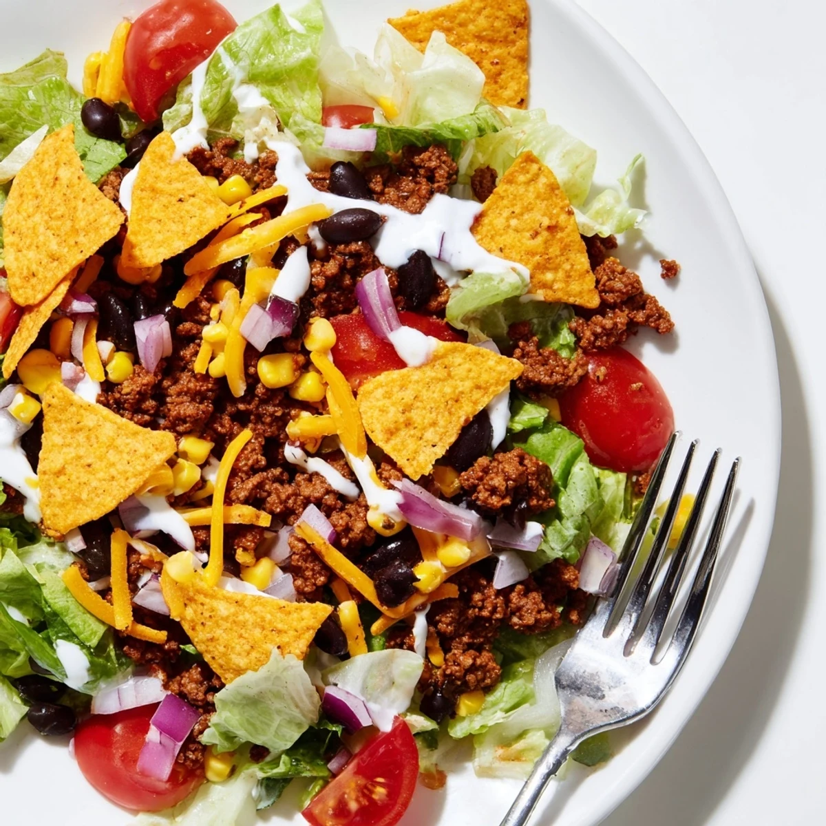 Bowl of Simple Doritos Taco Salad topped with warm seasoned beef and cheddar