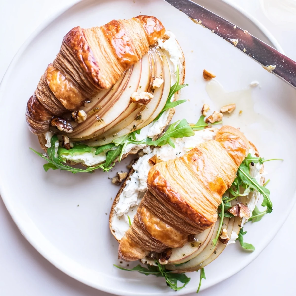 Assembled Apple Goat Cheese Croissant Sandwich ready for light lunch, arugula peeking