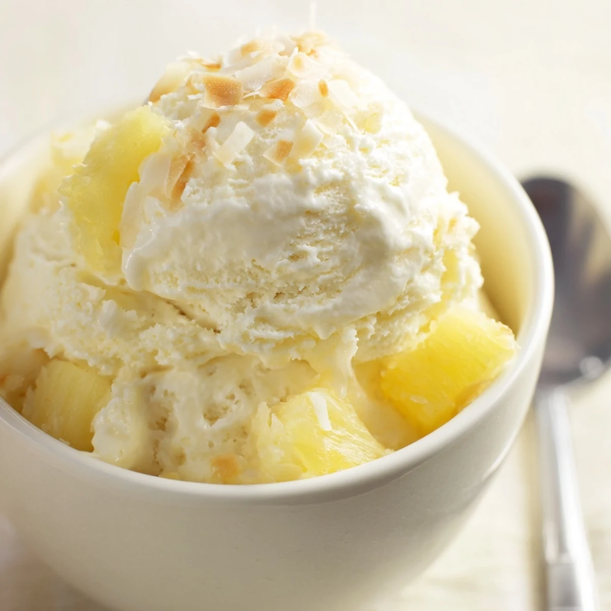 Homemade Creamy Pineapple Ice Cream flecked with juicy bites, silky texture.