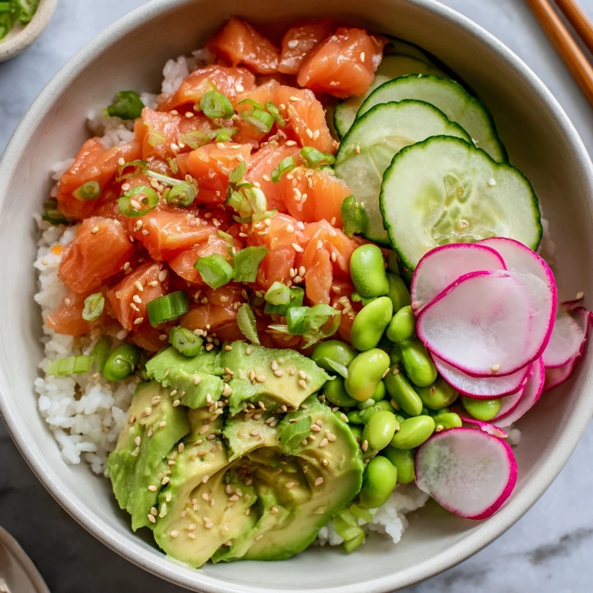 Colorful salmon and avocado poke bowl with fresh vegetables over seasoned white rice