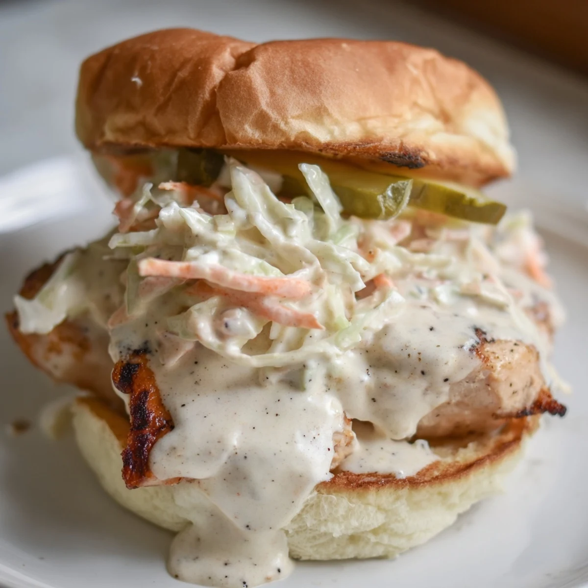 Heaping Alabama BBQ Chicken Chopped Sandwich with coleslaw and pickles on soft golden bun
