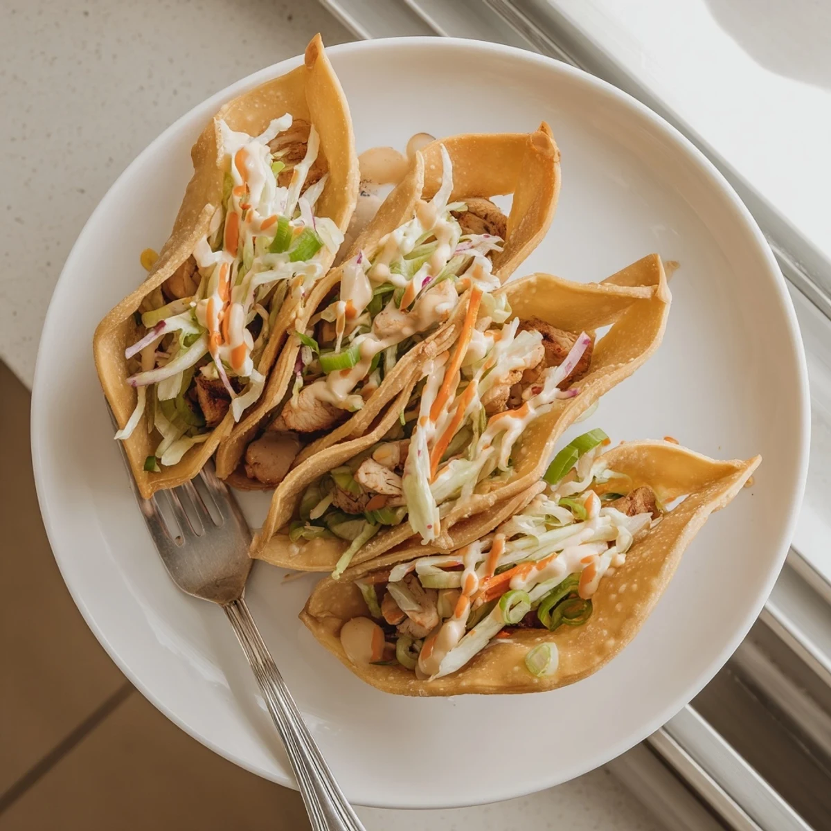 Crispy fried wonton shell tacos piled high with seasoned Asian chicken and zesty spicy cream sauce