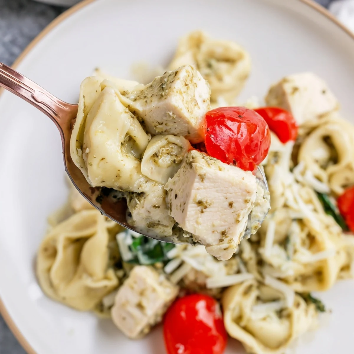 Family style Slow Cooker Tortellini Casserole With Cheesy Chicken Pesto, spooned beside crusty bread