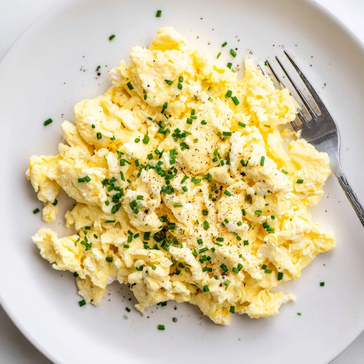 Cottage Cheese Scrambled Eggs With Chives steaming on skillet, soft creamy curds