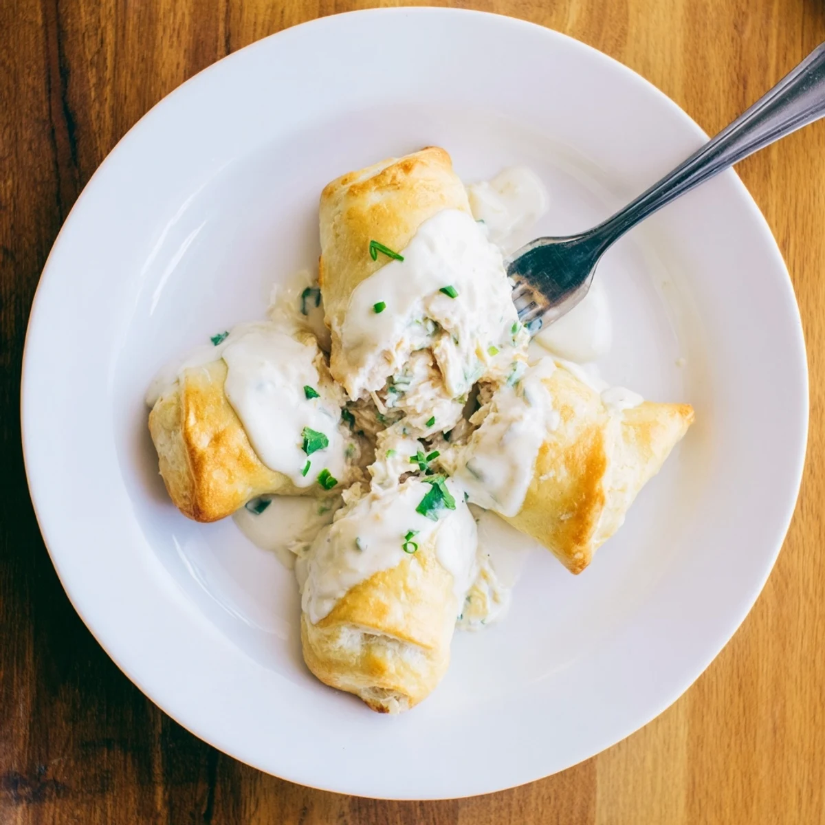 Golden chicken pillows wrapped in flaky crescent dough drizzled with rich parmesan sauce
