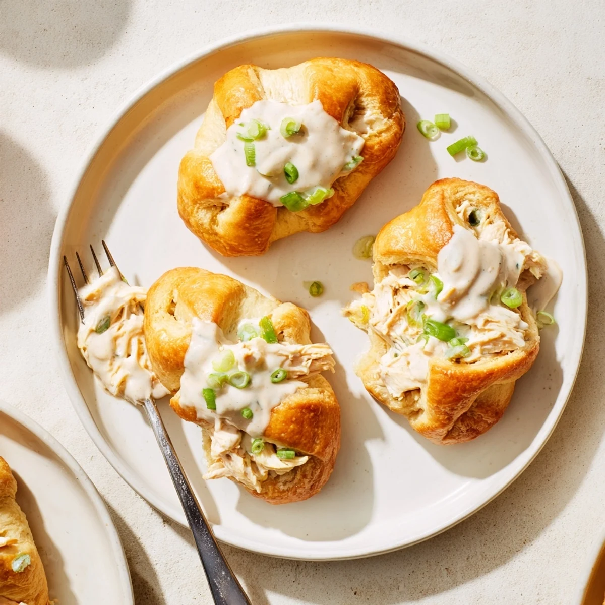 Creamy chicken and cream cheese filling baked inside buttery pastry with white parmesan sauce