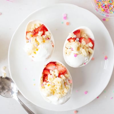 Festive strawberry shortcake Easter egg bombs with crisp white chocolate shells and juicy red berry filling